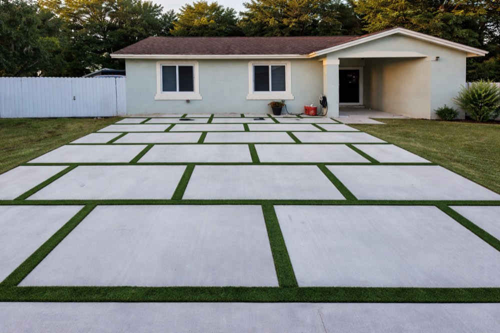Finished concrete pad driveway with turf ribbons at dusk, South Florida