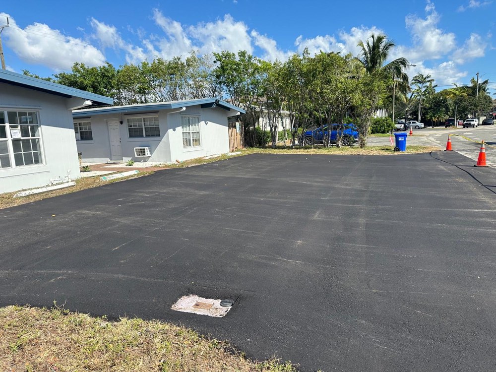 Fresh commercial asphalt lot with safety cones at a South Florida property